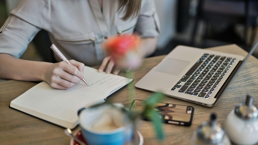 How-to-Build-Content-Pillars-for-Your-Health-&-Wellness-Blog-Supporting A health and wellness professional makes notes in their notebook during a keyword research session.