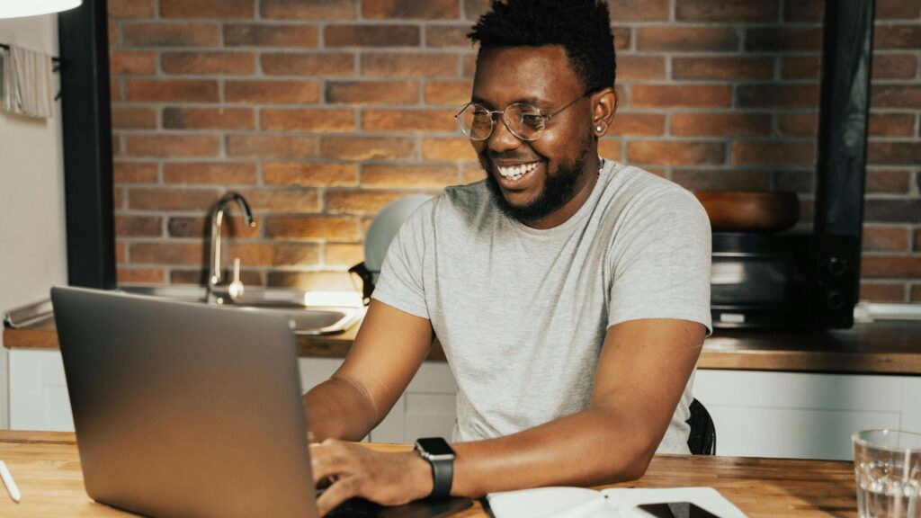 Ways-to-Market-Yourself-as-a-Health-&-Wellness-Professional-Supporting A personal trainer smiles as he builds his social media presence to meet his marketing efforts.